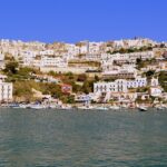 Vista panoramica su una delle isole italiane economiche per l'estate, con mare cristallino e spiagge dorate.