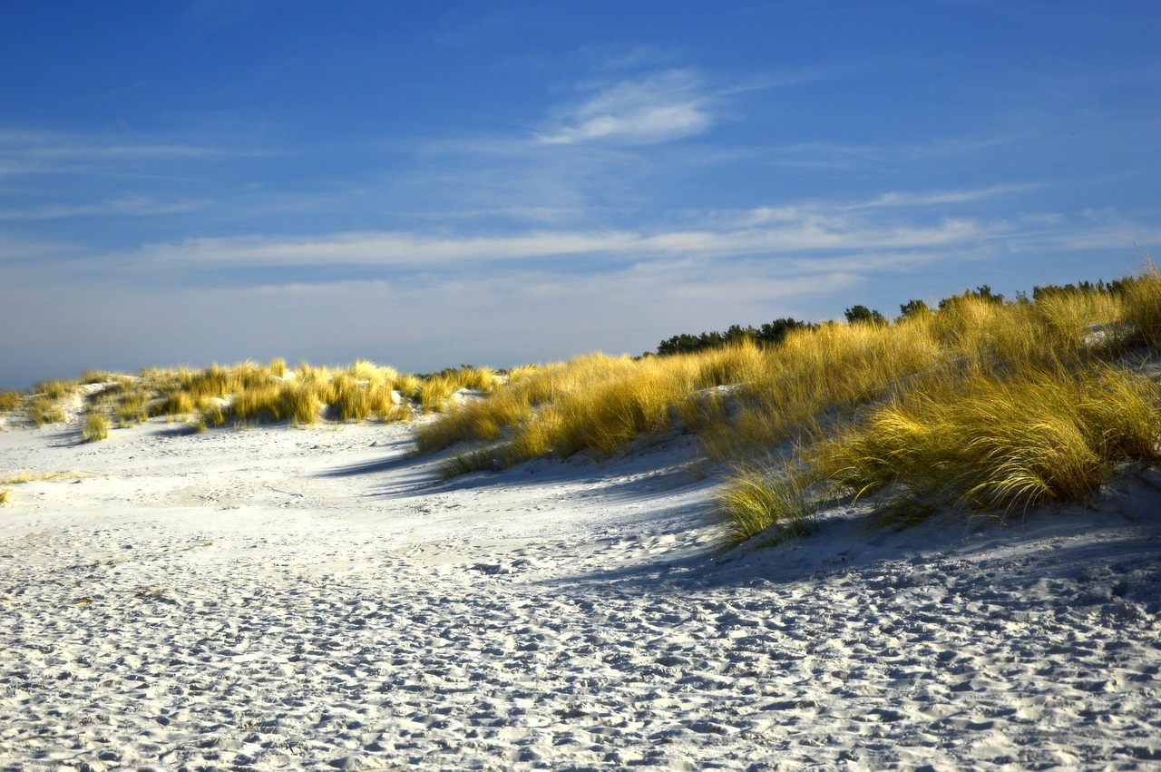 Persona che cammina a piedi nudi su dune sabbiose in uno dei lidi italiani.