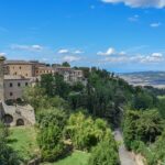 Vista panoramica delle colline umbre con borghi storici e vigneti in un weekend enogastronomico.