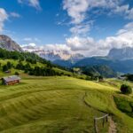 Vista panoramica delle Dolomiti con sentieri e vegetazione, ideale per una vacanza sostenibile.