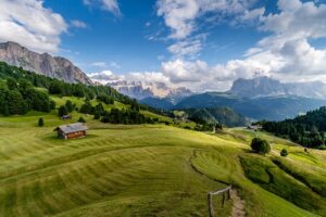 Vista panoramica delle Dolomiti con sentieri e vegetazione, ideale per una vacanza sostenibile.