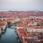Vista panoramica del lago con vicoli caratteristici di Venezia lombarda, arte e bellezza naturale.