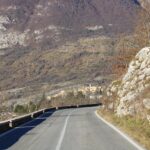 Vista mozzafiato della strada panoramica in Italia, circondata da montagne e paesaggi incantevoli.