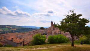 Paesaggio sereno dell'Umbria, con colline verdi e cielo azzurro, rappresentante la tranquillità del paese.