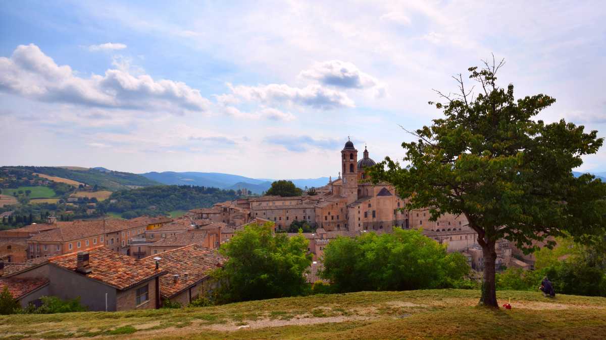 Paesaggio sereno dell'Umbria, con colline verdi e cielo azzurro, rappresentante la tranquillità del paese.