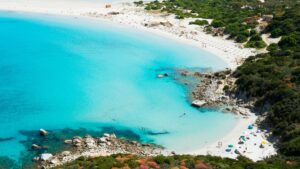 Spiaggia incontaminata della Sardegna, accessibile solo a piedi, con acque cristalline e sabbia bianca.