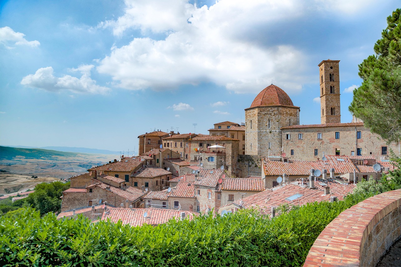 Fioritura in Toscana: panoramica di un borgo fiorito con colline e piante in fiore.