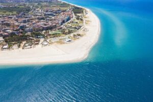 Spiaggia incantevole dell'Abruzzo con sabbia dorata e acque cristalline, circondata da un paesaggio naturale.