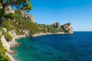 Vista panoramica di un'isola minore toscana, con acque cristalline e vegetazione lussureggiante.